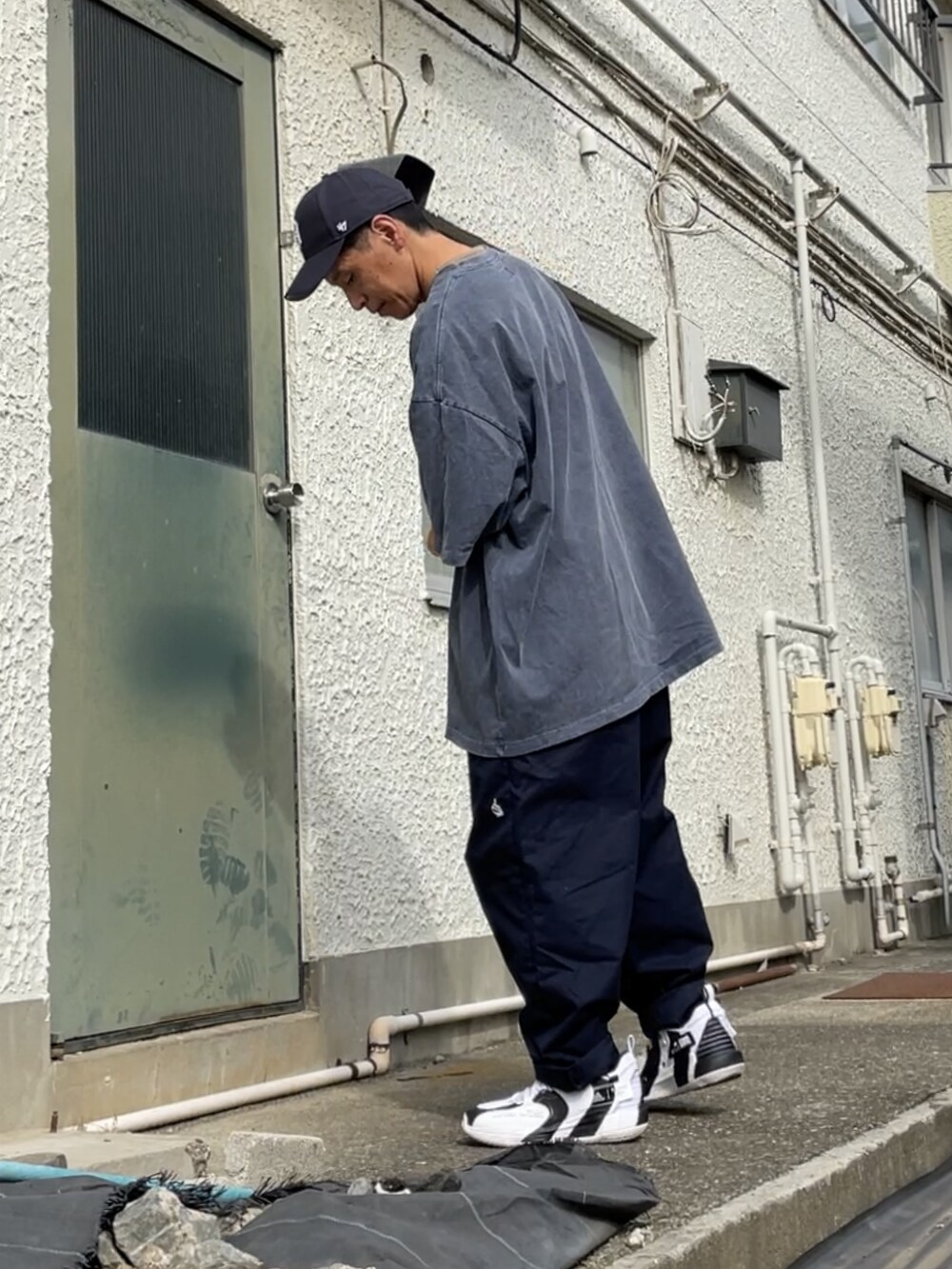 ホワイト系のスニーカー、ブルー系のチノパンツ、ブルー系のTシャツ/カットソーを着用したメンズの秋コーディネートの2枚目の写真