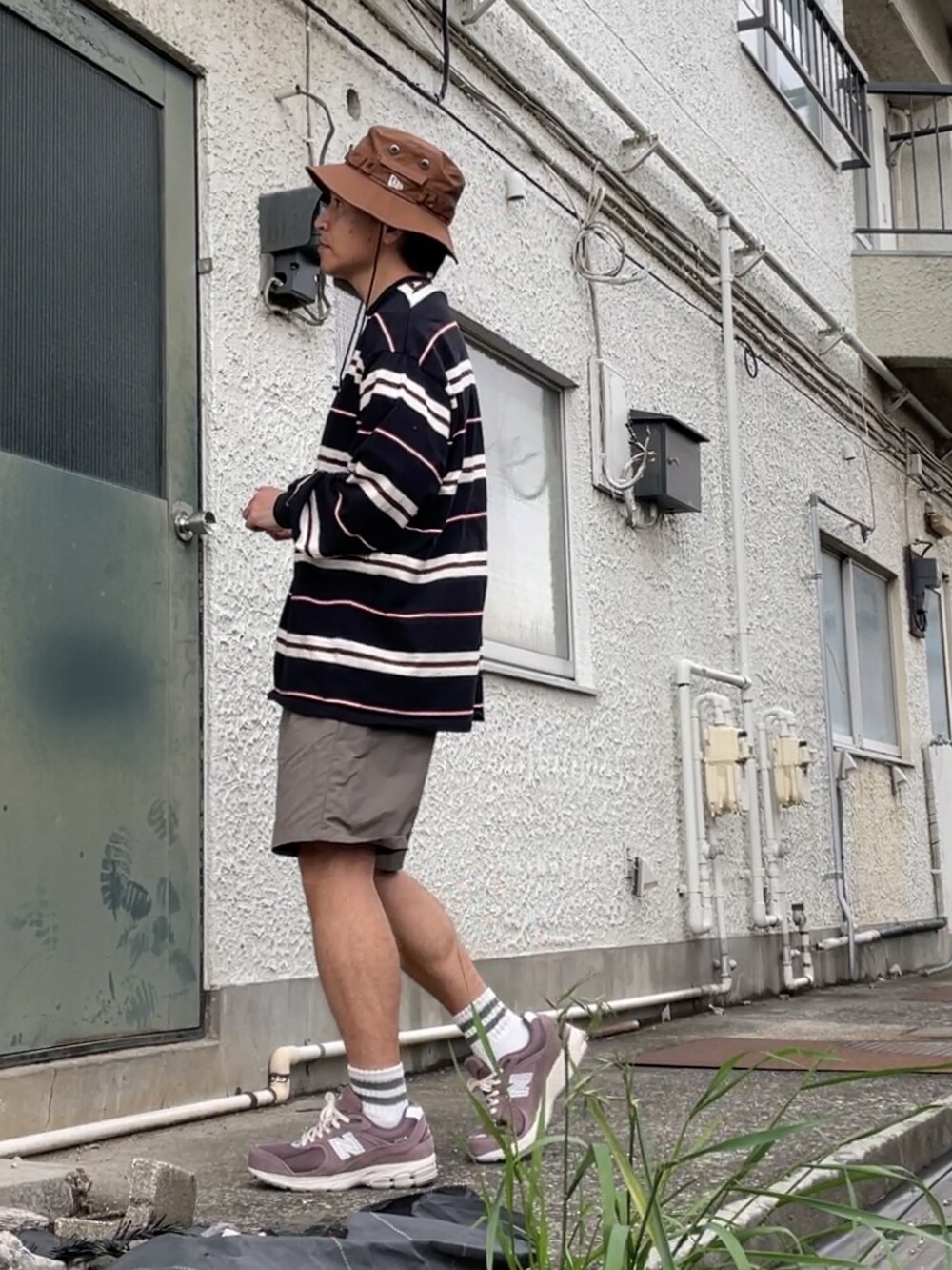 ブラウン系のスニーカー、ブラウン系のその他パンツ、ブラック系のTシャツ/カットソーを着用したメンズの春コーディネートの3枚目の写真