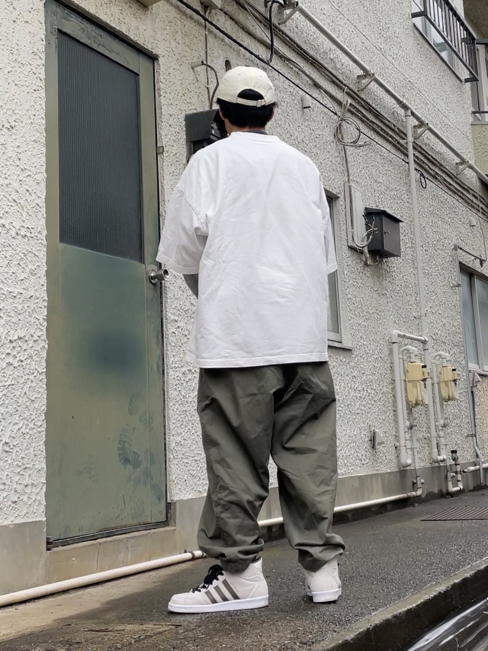 ホワイト系のスニーカー、グリーン系のその他パンツ、ホワイト系のTシャツ/カットソーを着用したメンズの春コーディネートの2枚目の写真