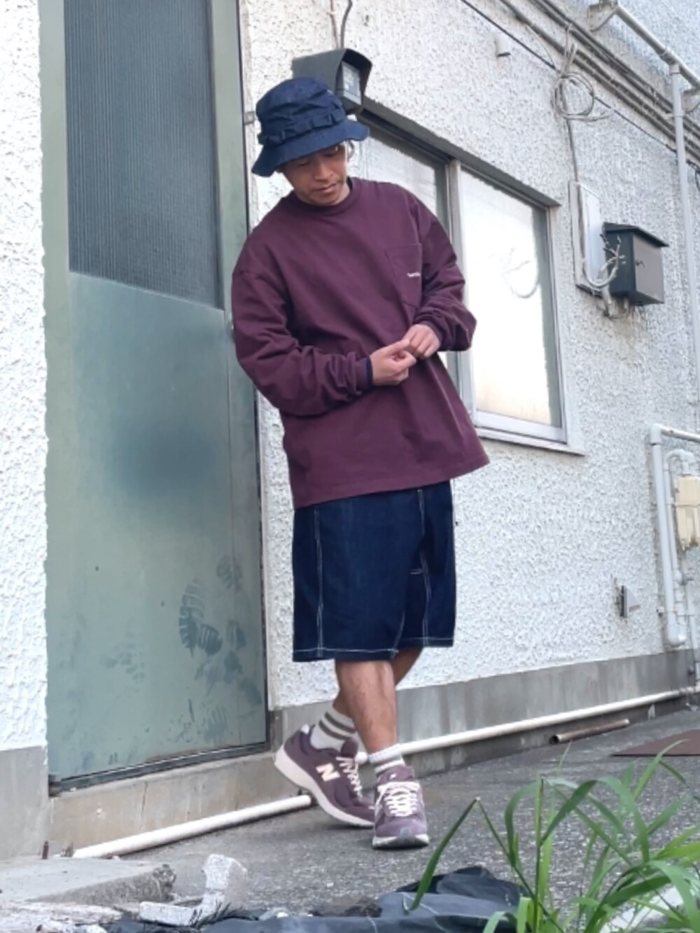 ブラウン系のスニーカー、ブルー系のデニムパンツ、レッド系のスウェットを着用したメンズの春コーディネートの3枚目の写真
