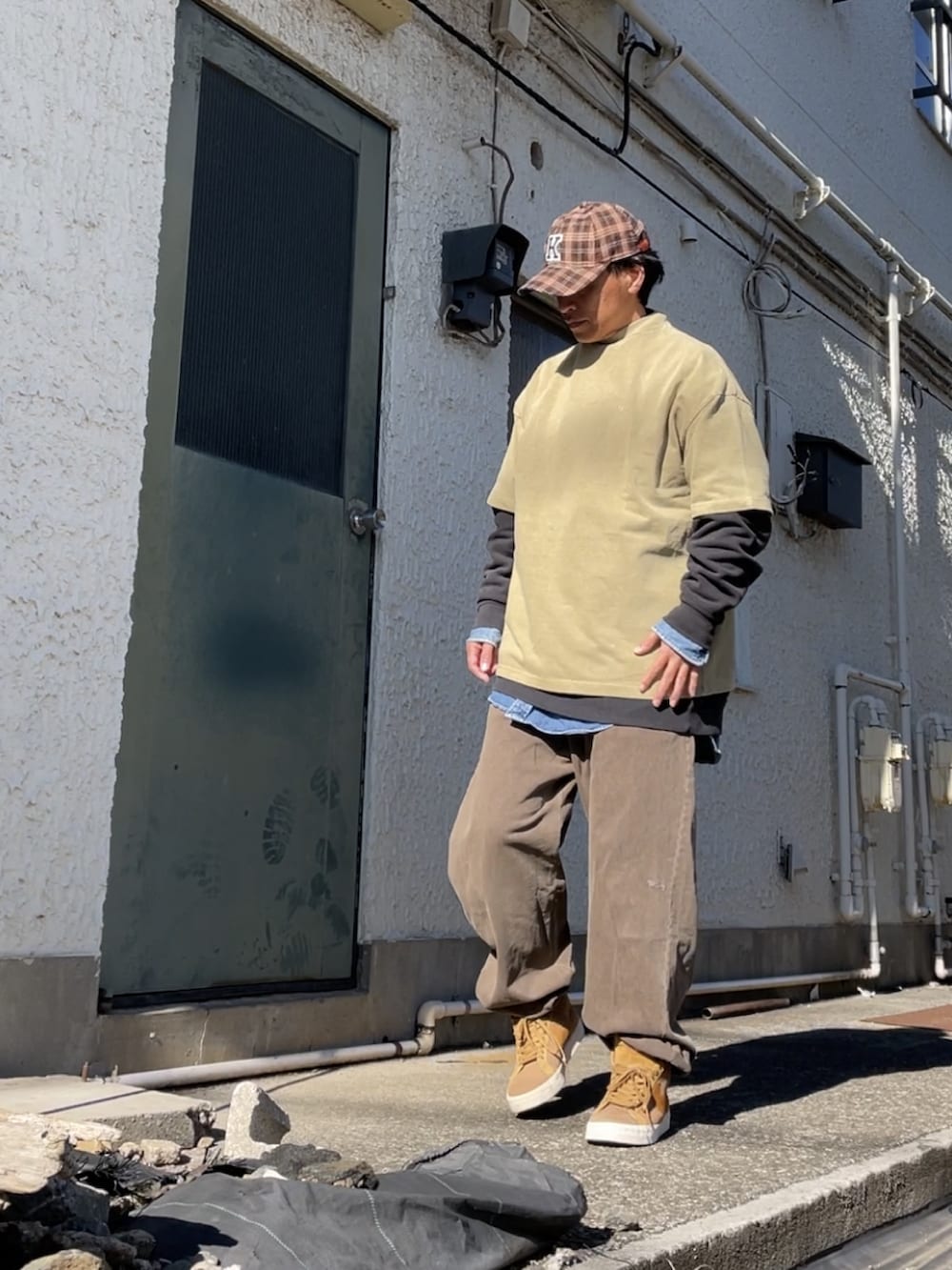 ブラウン系のスニーカー、ブラウン系のその他パンツ、グリーン系のTシャツ/カットソーを着用したメンズの冬コーディネートの2枚目の写真