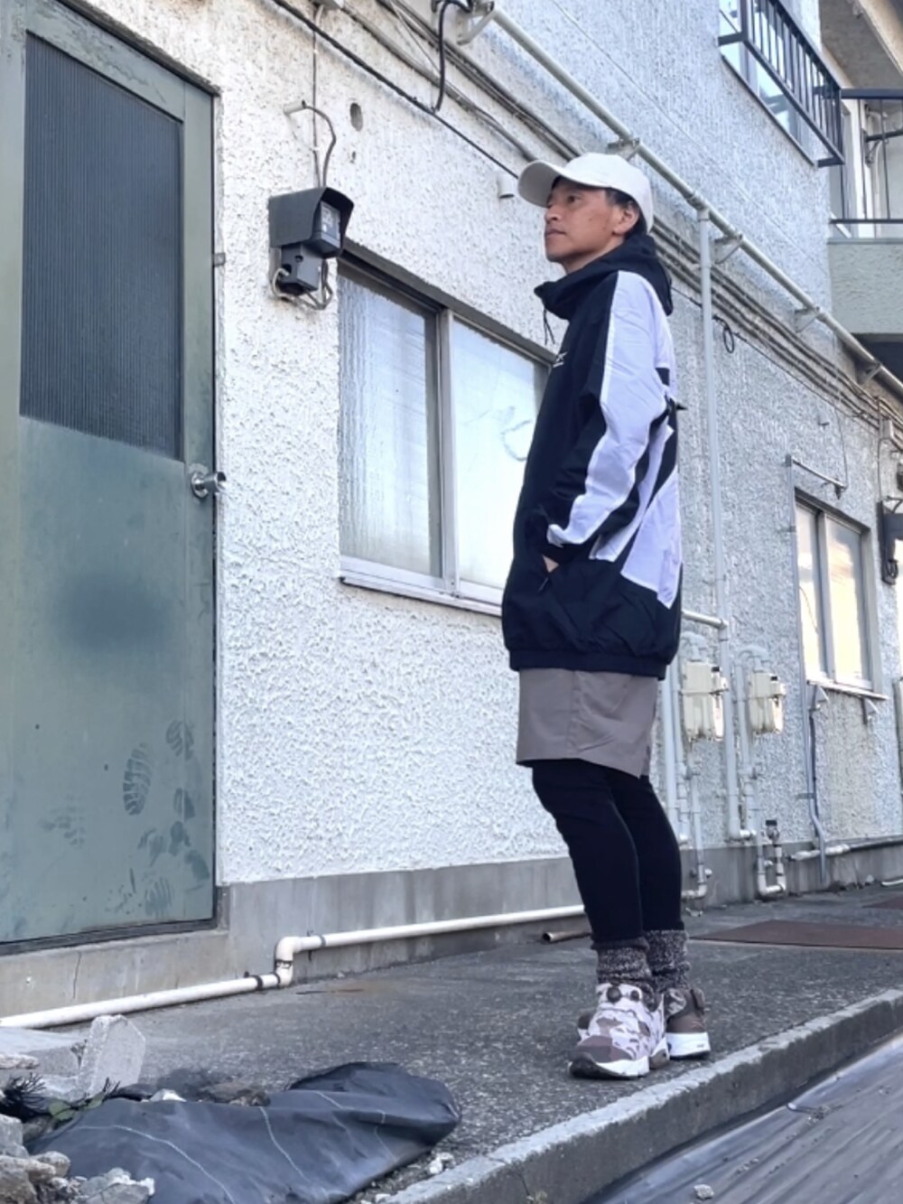 ブラウン系のスニーカー、ブラック系のマウンテンパーカー、ブラウン系のその他パンツを着用したメンズの冬コーディネートの2枚目の写真