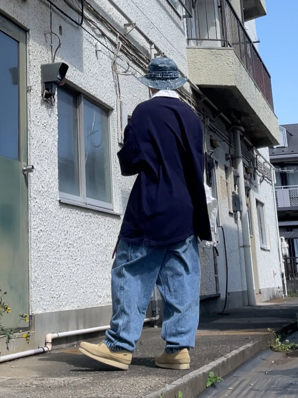 ベージュ系のモカシン/デッキシューズ、ブルー系のデニムパンツ、ブルー系のTシャツ/カットソーを着用したメンズの春コーディネートの2枚目の写真