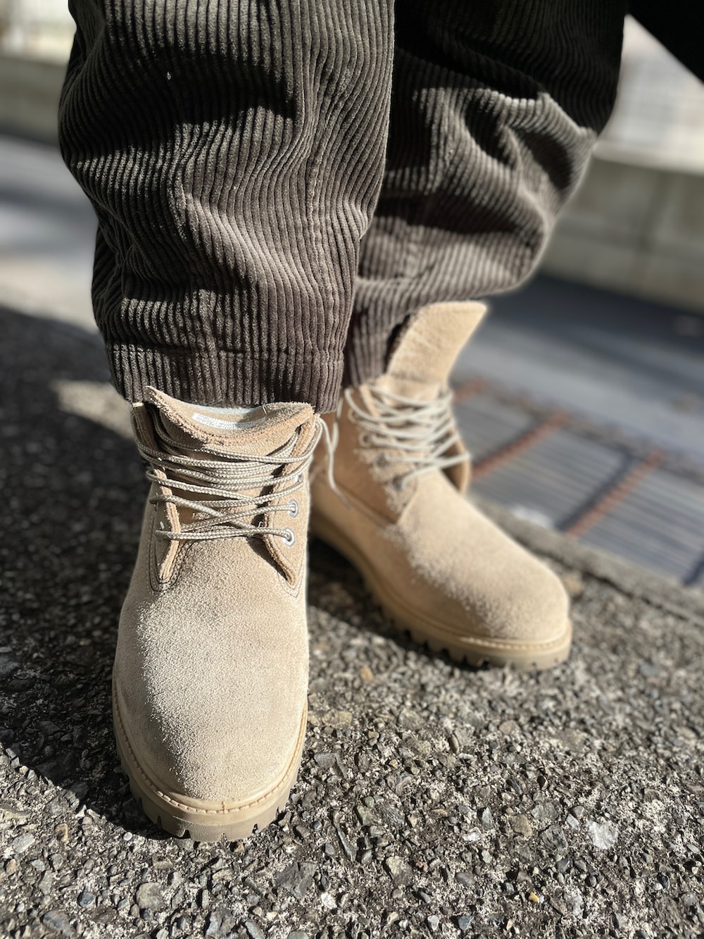 ベージュ系のブーツ、グリーン系のその他パンツ、ブルー系のステンカラーコートを着用したメンズの冬コーディネートの3枚目の写真