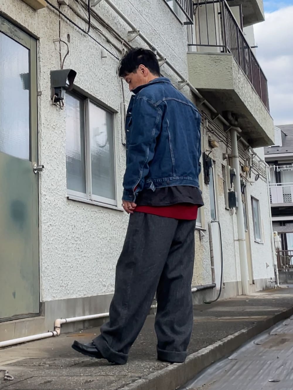 レッド系のニット/セーター、ブラック系のシャツ/ブラウス、ブルー系のデニムジャケットを着用したメンズの冬コーディネートの2枚目の写真