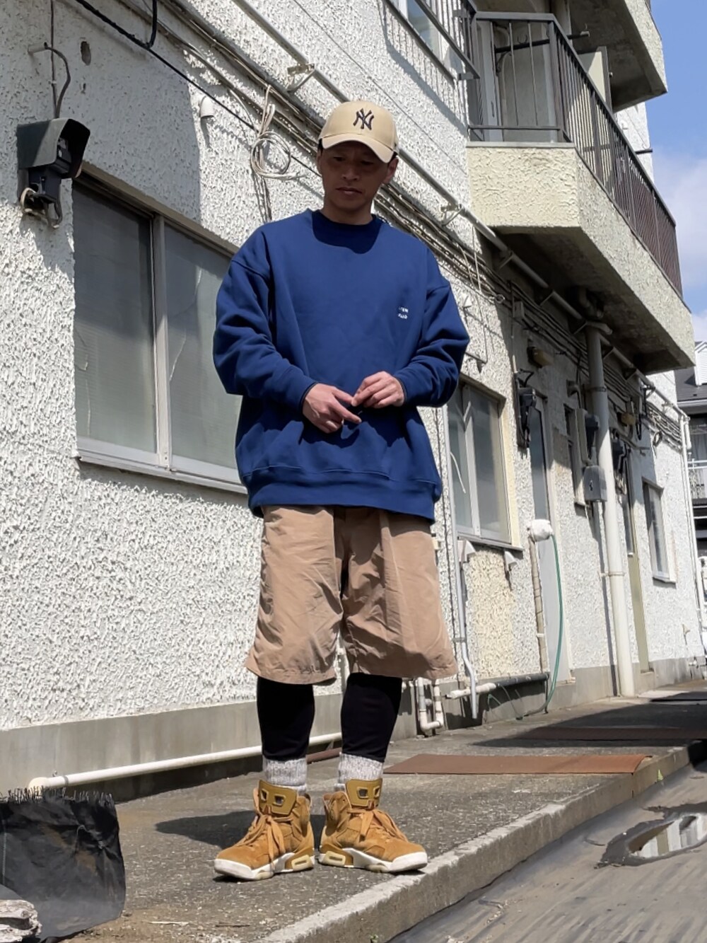 ブラウン系のスニーカー、ベージュ系のその他パンツ、ブルー系のスウェットを着用したメンズの春コーディネートの2枚目の写真