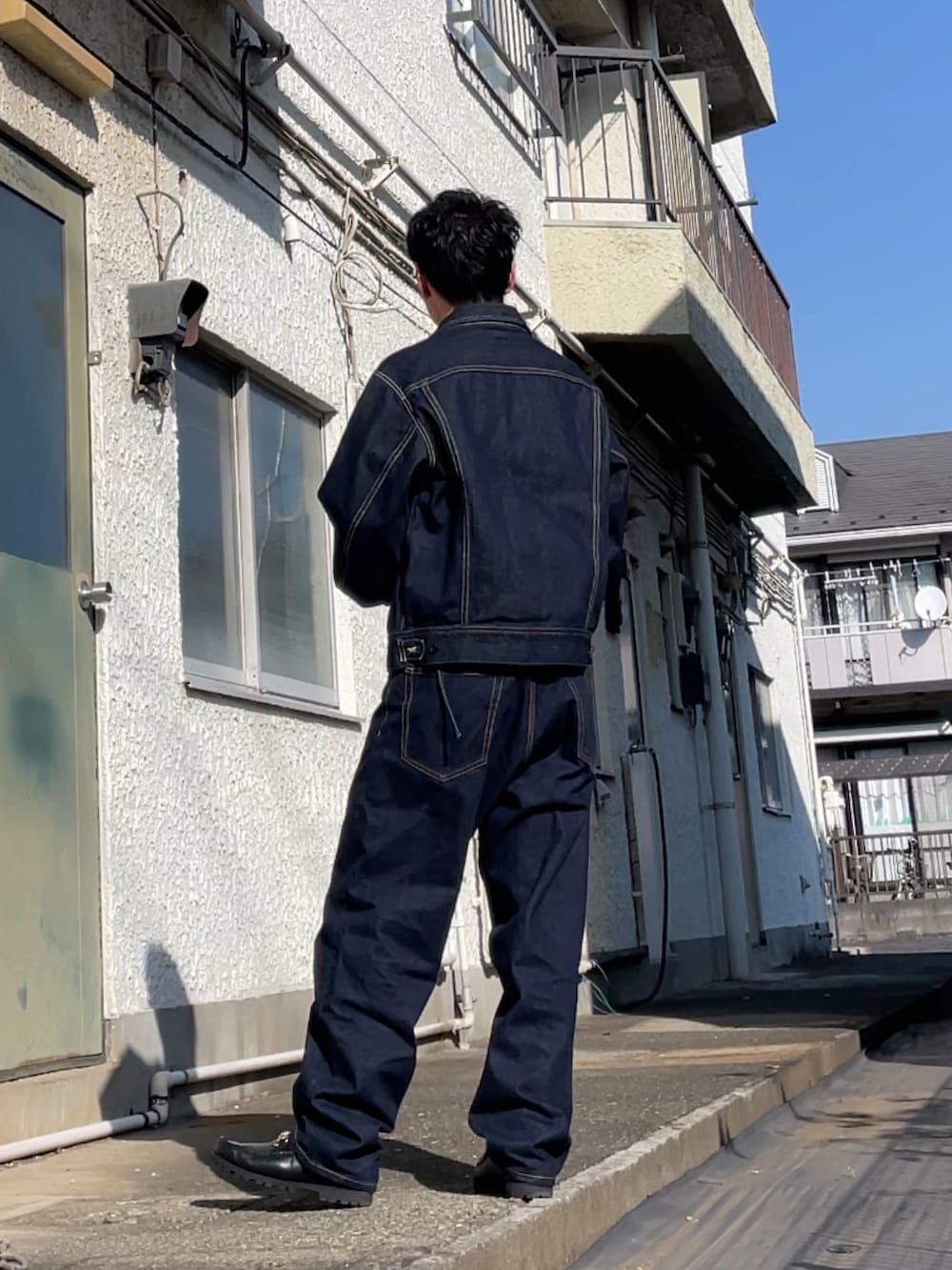 ブラック系のブーツ、ブルー系のデニムパンツ、ブルー系のデニムジャケットを着用したメンズの春コーディネートの2枚目の写真