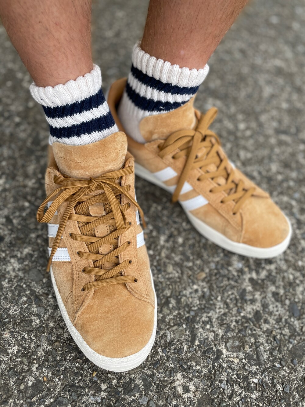 ブラウン系のスニーカー、ブルー系のデニムパンツ、ブラック系のTシャツ/カットソーを着用したメンズの夏コーディネートの2枚目の写真