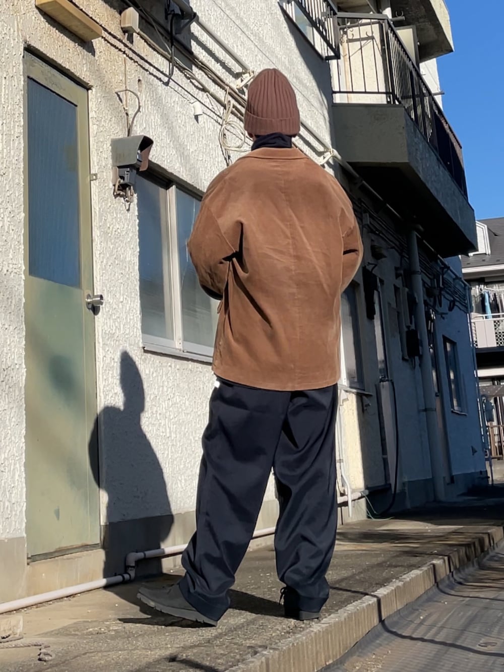 ブルー系のTシャツ/カットソー、ブルー系のスラックス、ブラック系のブーツを着用したメンズの冬コーディネートの2枚目の写真