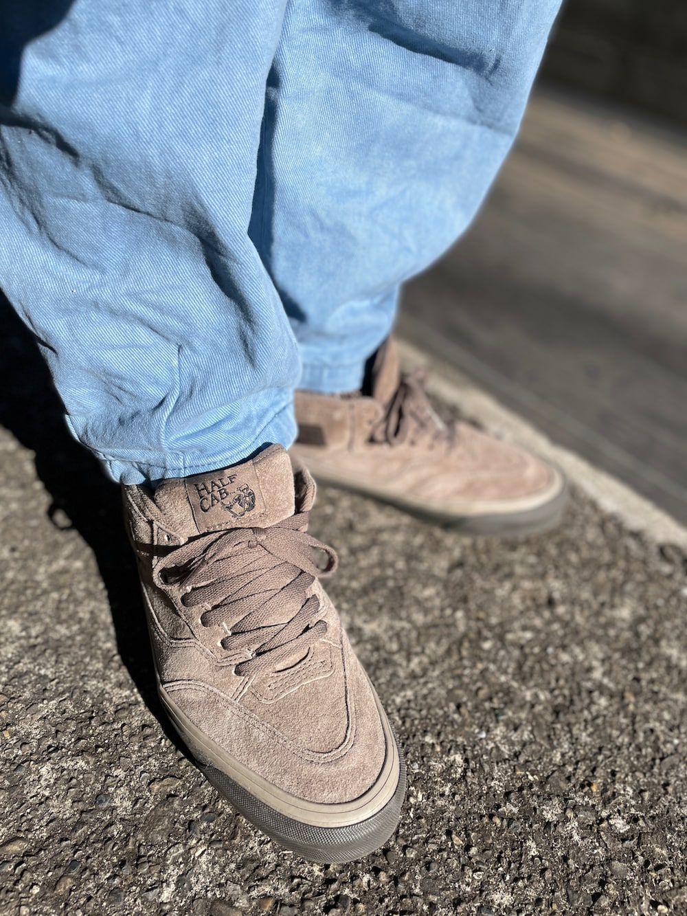 ベージュ系のスニーカー、ブルー系のデニムパンツ、ブラック系のスウェットを着用したメンズの冬コーディネートの3枚目の写真