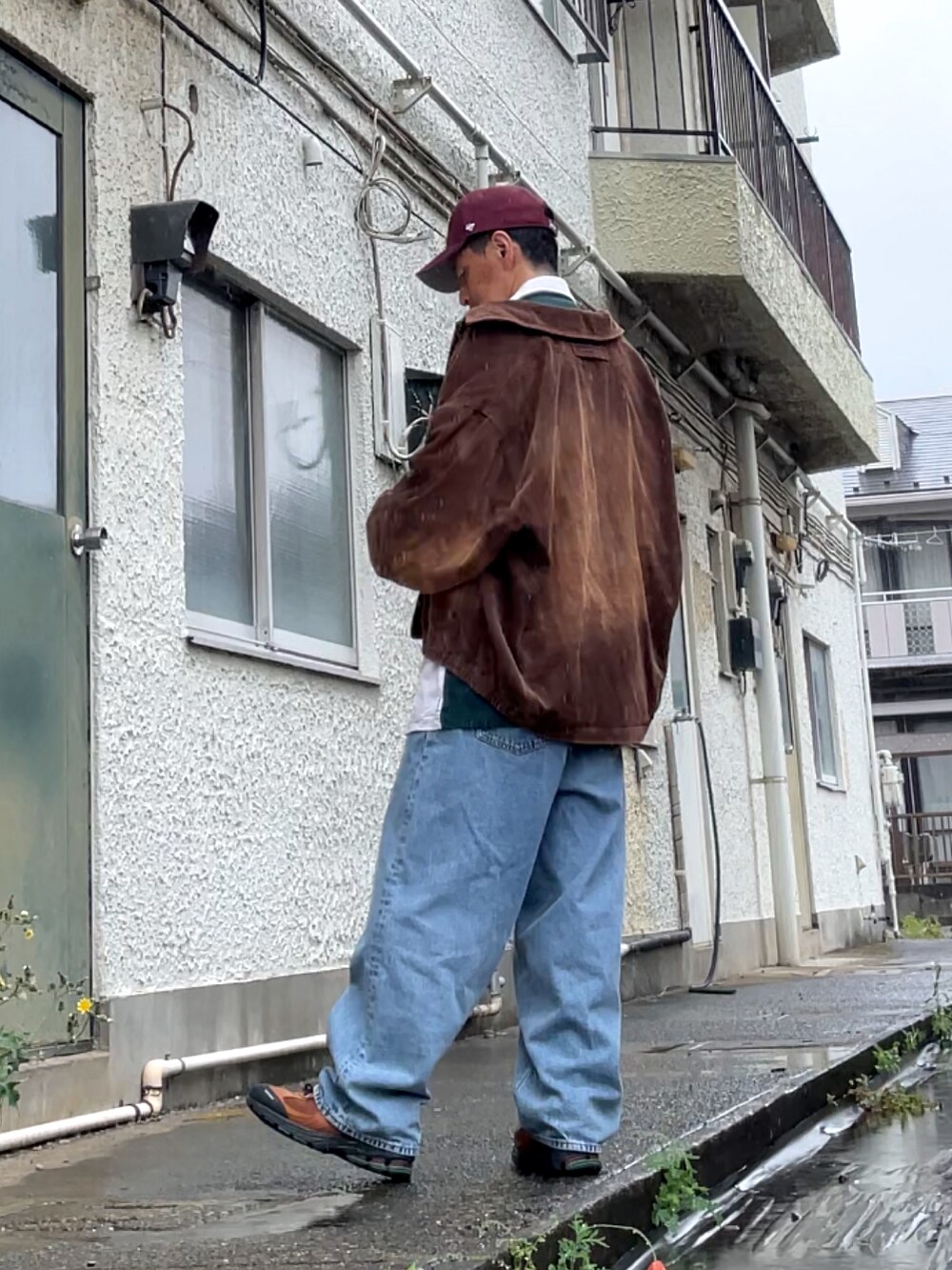 ブラウン系のスニーカー、ブルー系のデニムパンツ、グリーン系のポロシャツを着用したメンズの春コーディネートの2枚目の写真