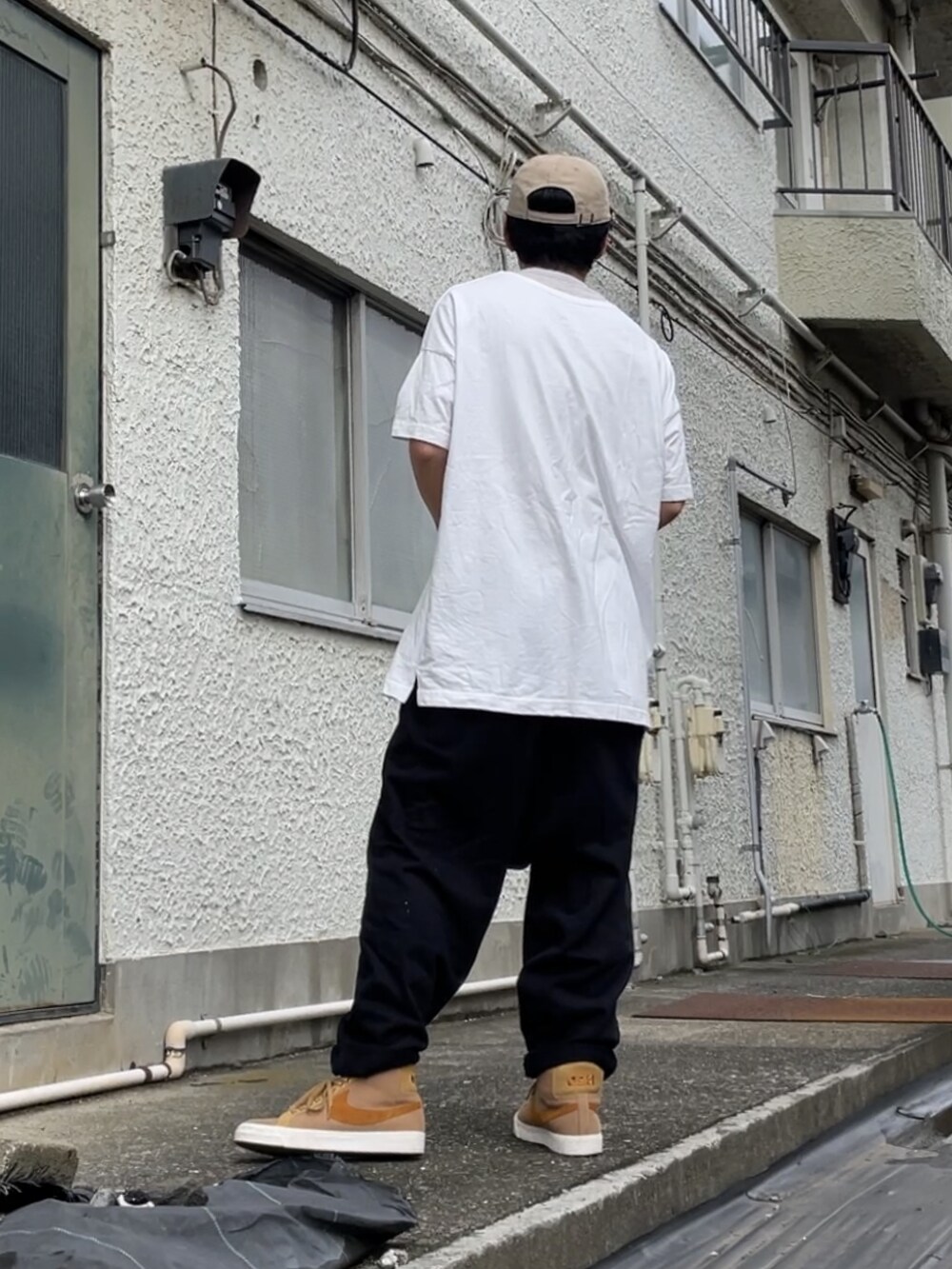 ブラウン系のスニーカー、ブラック系のその他パンツ、ホワイト系のTシャツ/カットソーを着用したメンズの秋コーディネートの2枚目の写真