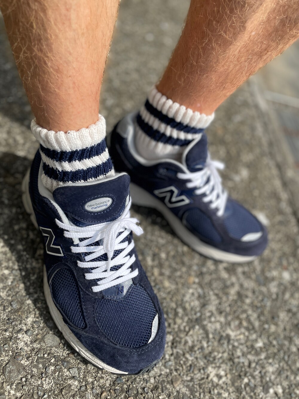 ブルー系のスニーカー、ブルー系のデニムパンツ、ホワイト系のTシャツ/カットソーを着用したメンズの秋コーディネートの2枚目の写真