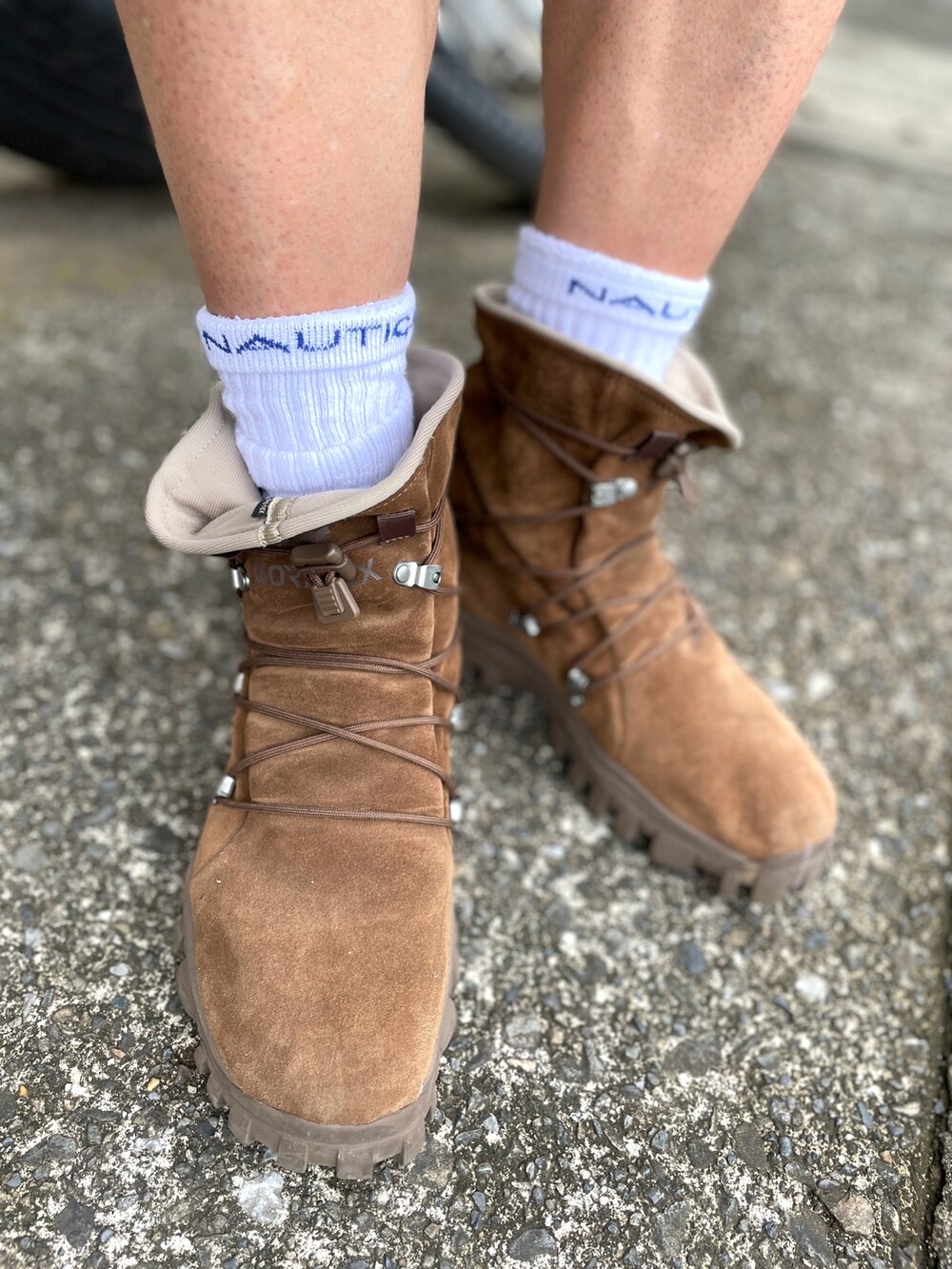 ブルー系のポロシャツ、ベージュ系のチノパンツ、ブラウン系のブーツを着用したメンズの秋コーディネートの3枚目の写真