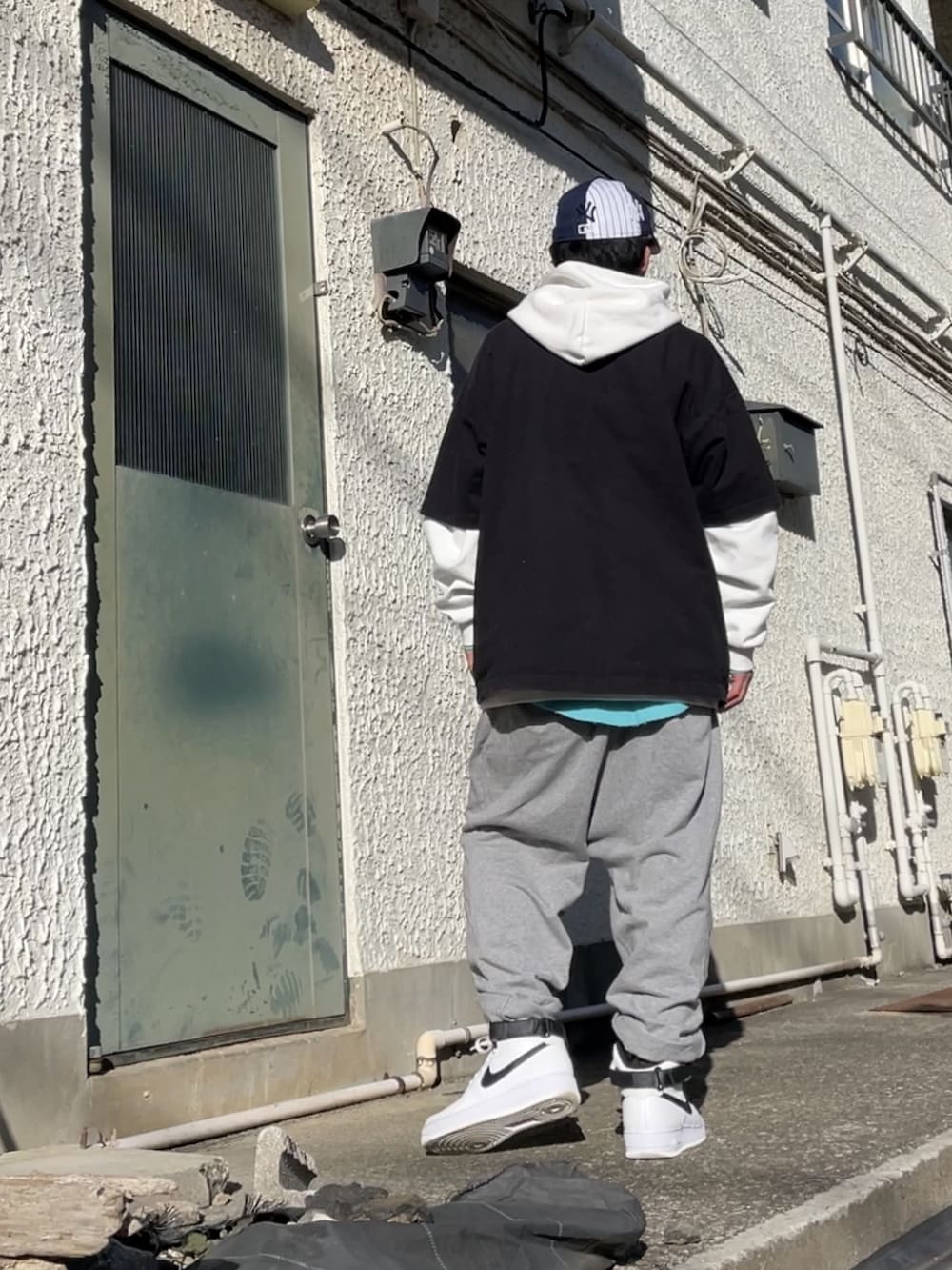 ホワイト系のスニーカー、グレー系のその他パンツ、ブラック系のTシャツ/カットソーを着用したメンズの冬コーディネートの3枚目の写真