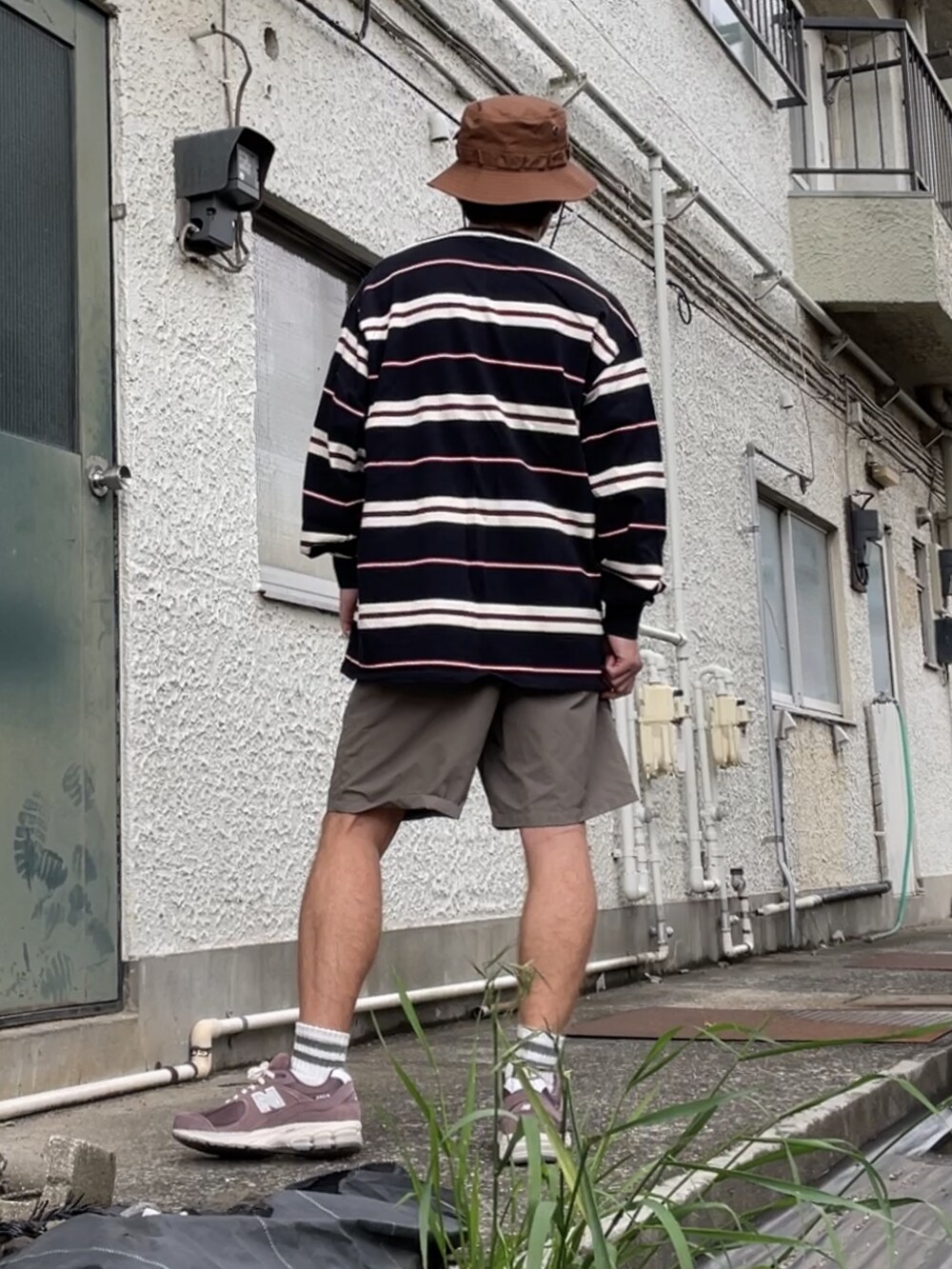 ブラウン系のスニーカー、ブラウン系のその他パンツ、ブラック系のTシャツ/カットソーを着用したメンズの春コーディネートの4枚目の写真