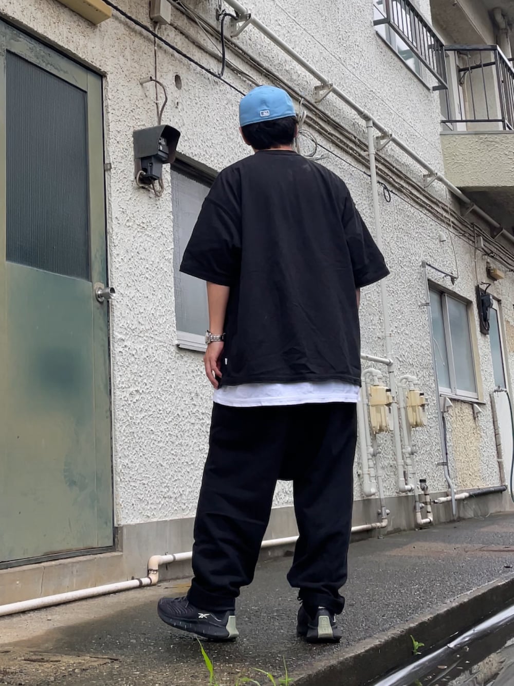 グレー系のスニーカー、ブラック系のその他パンツ、ブラック系のTシャツ/カットソーを着用したメンズの夏コーディネートの2枚目の写真