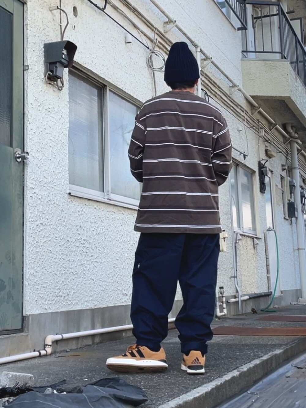 ブラウン系のスニーカー、ブルー系のその他パンツ、グレー系のTシャツ/カットソーを着用したメンズの秋コーディネートの2枚目の写真