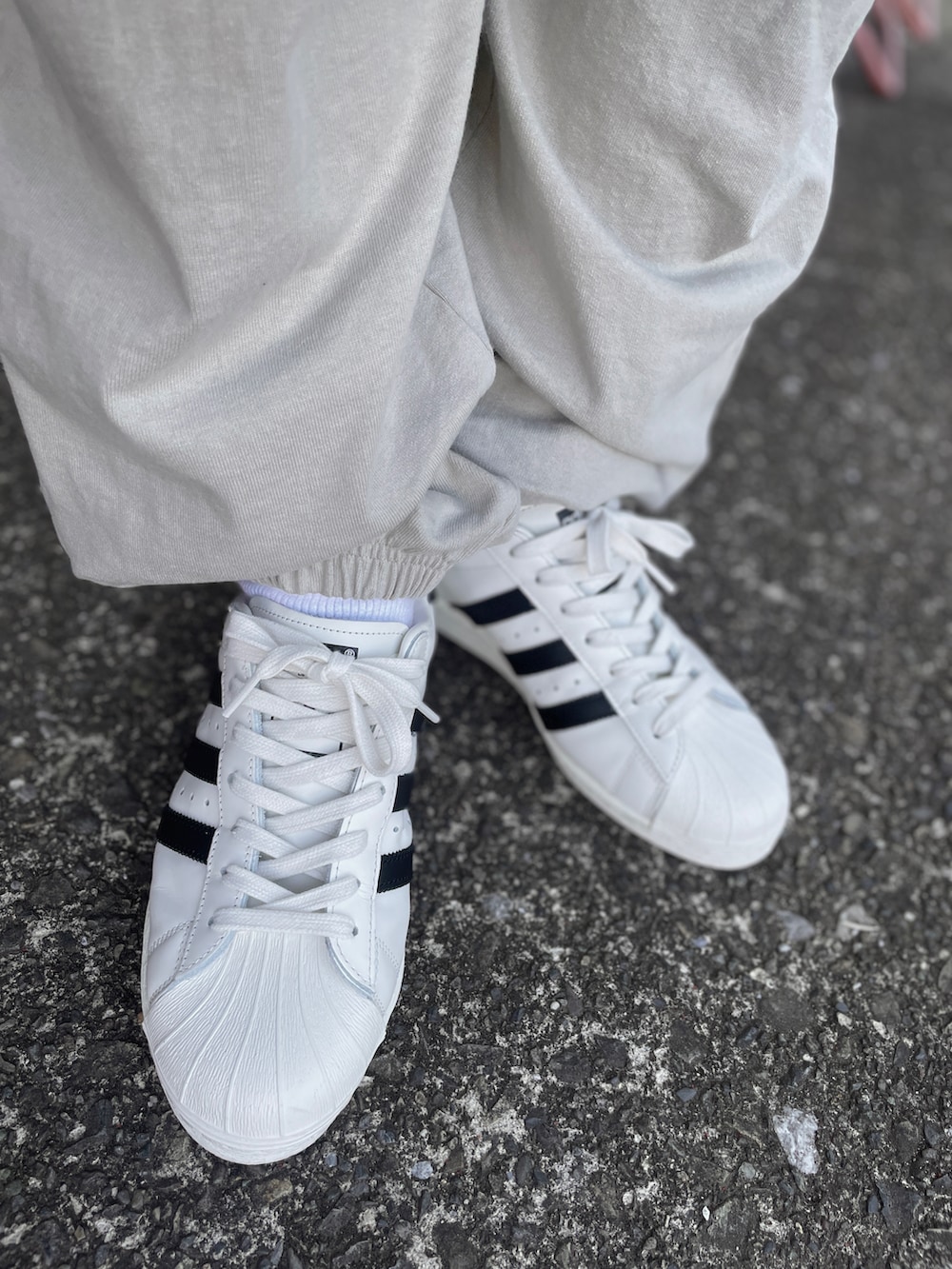 ホワイト系のスニーカー、グレー系のその他パンツ、ブラック系のTシャツ/カットソーを着用したメンズの春コーディネートの3枚目の写真