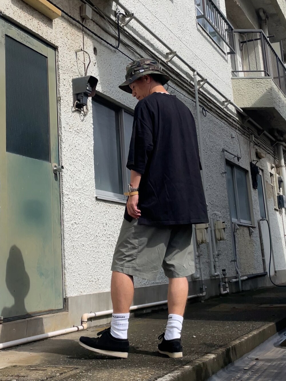 ブラック系のモカシン/デッキシューズ、ブラウン系のその他パンツ、ブラック系のTシャツ/カットソーを着用したメンズの夏コーディネートの2枚目の写真