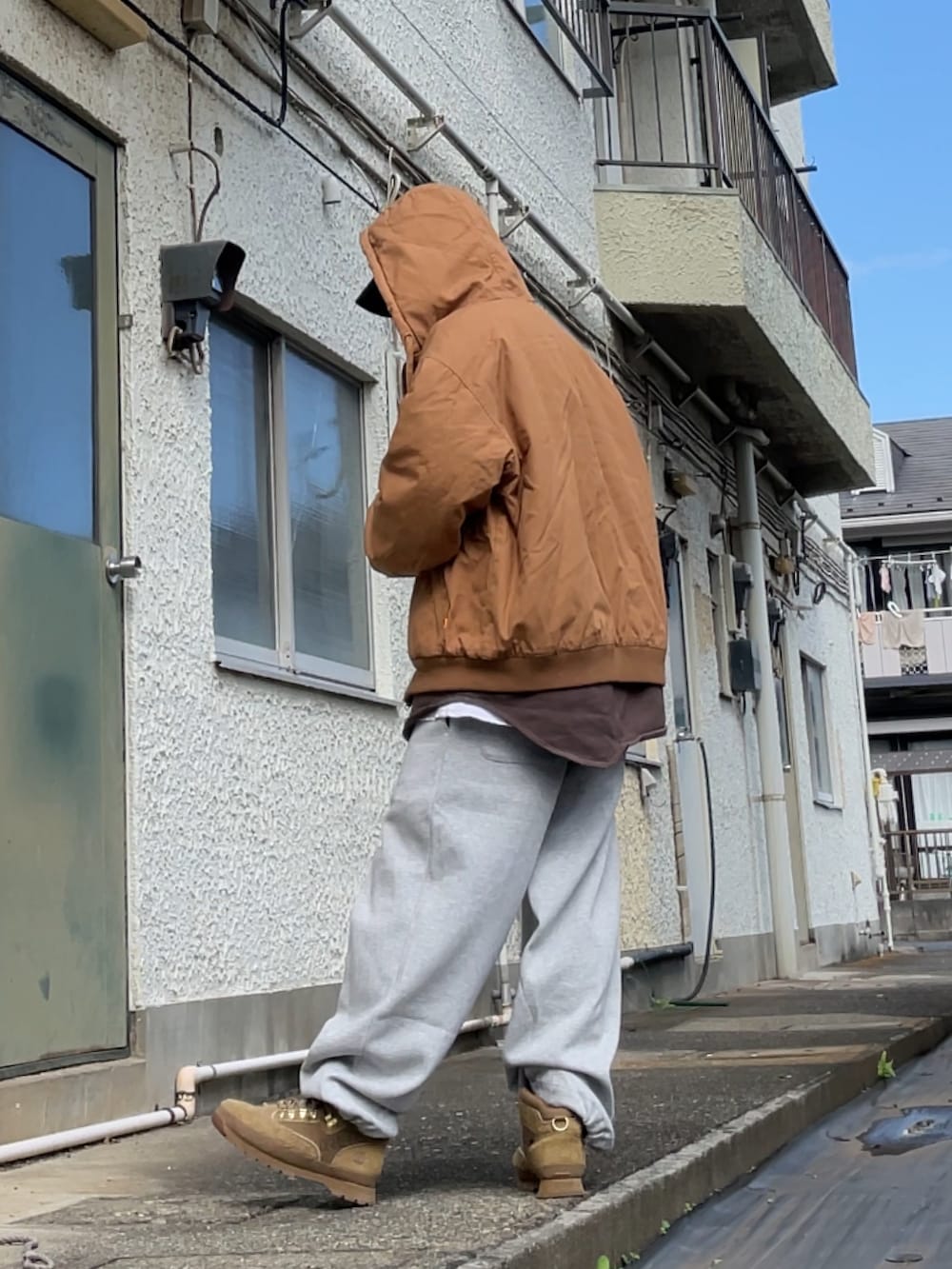 ブラウン系のブルゾン、ブラウン系のスウェット、グレー系のスウェットパンツを着用したメンズの秋コーディネートの2枚目の写真