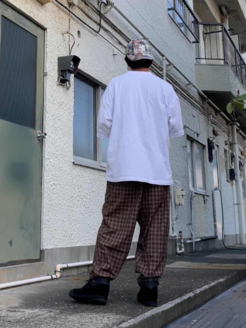 ブラック系のスニーカー、ブラウン系のその他パンツ、ホワイト系のTシャツ/カットソーを着用したメンズの秋コーディネートの2枚目の写真