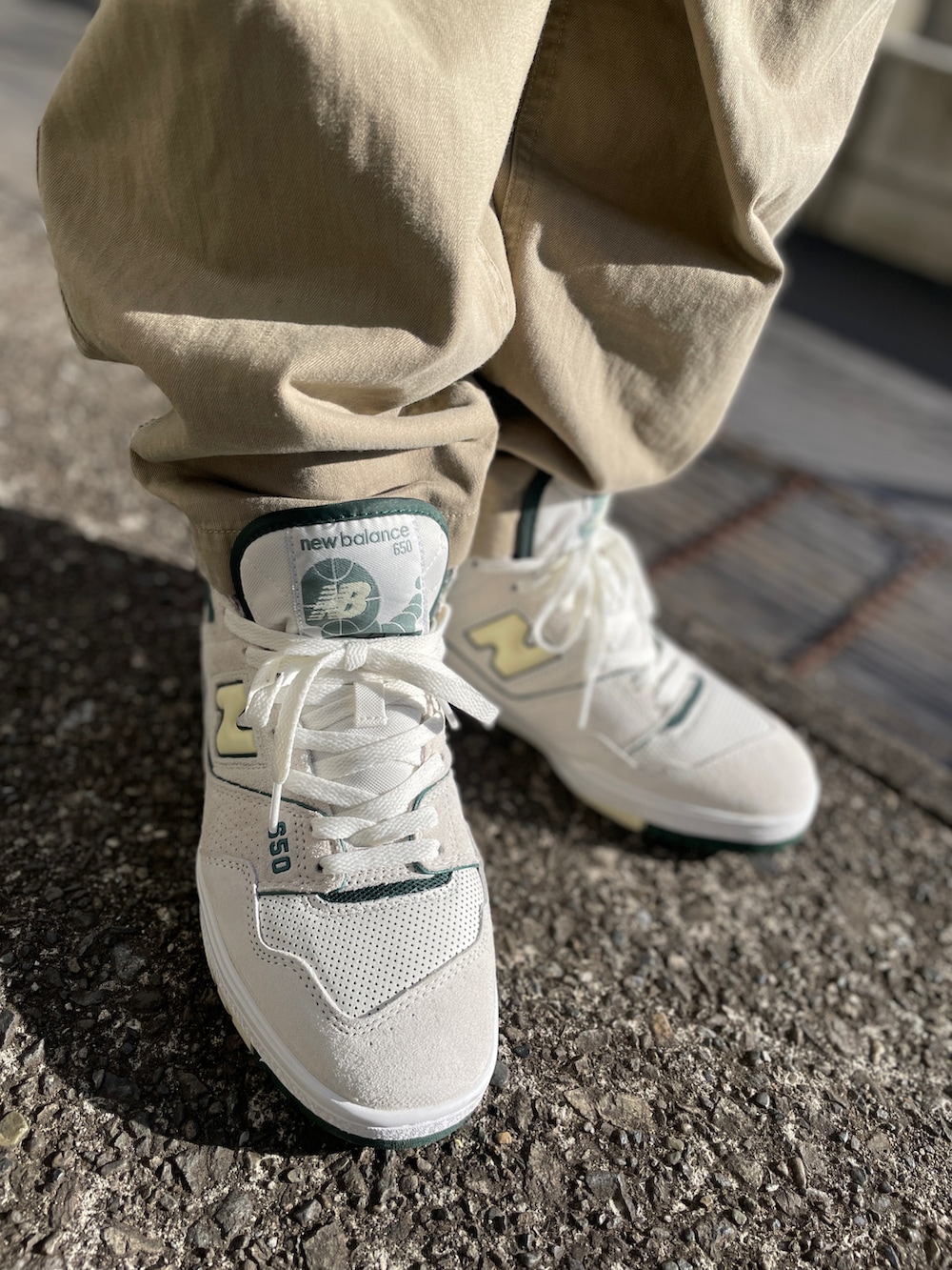 ホワイト系のスニーカー、ベージュ系のチノパンツ、グリーン系のパーカーを着用したメンズの冬コーディネートの3枚目の写真