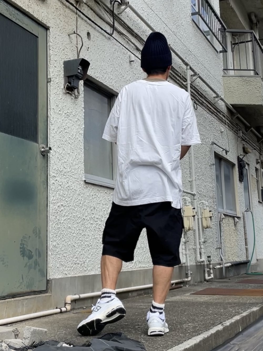 ホワイト系のスニーカー、ブラック系のその他パンツ、ホワイト系のTシャツ/カットソーを着用したメンズの秋コーディネートの2枚目の写真