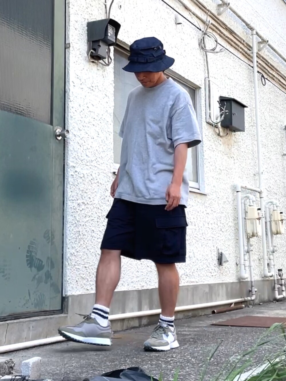 グリーン系のスニーカー、ブルー系のカーゴパンツ、グレー系のスウェットを着用したメンズの夏コーディネートの3枚目の写真