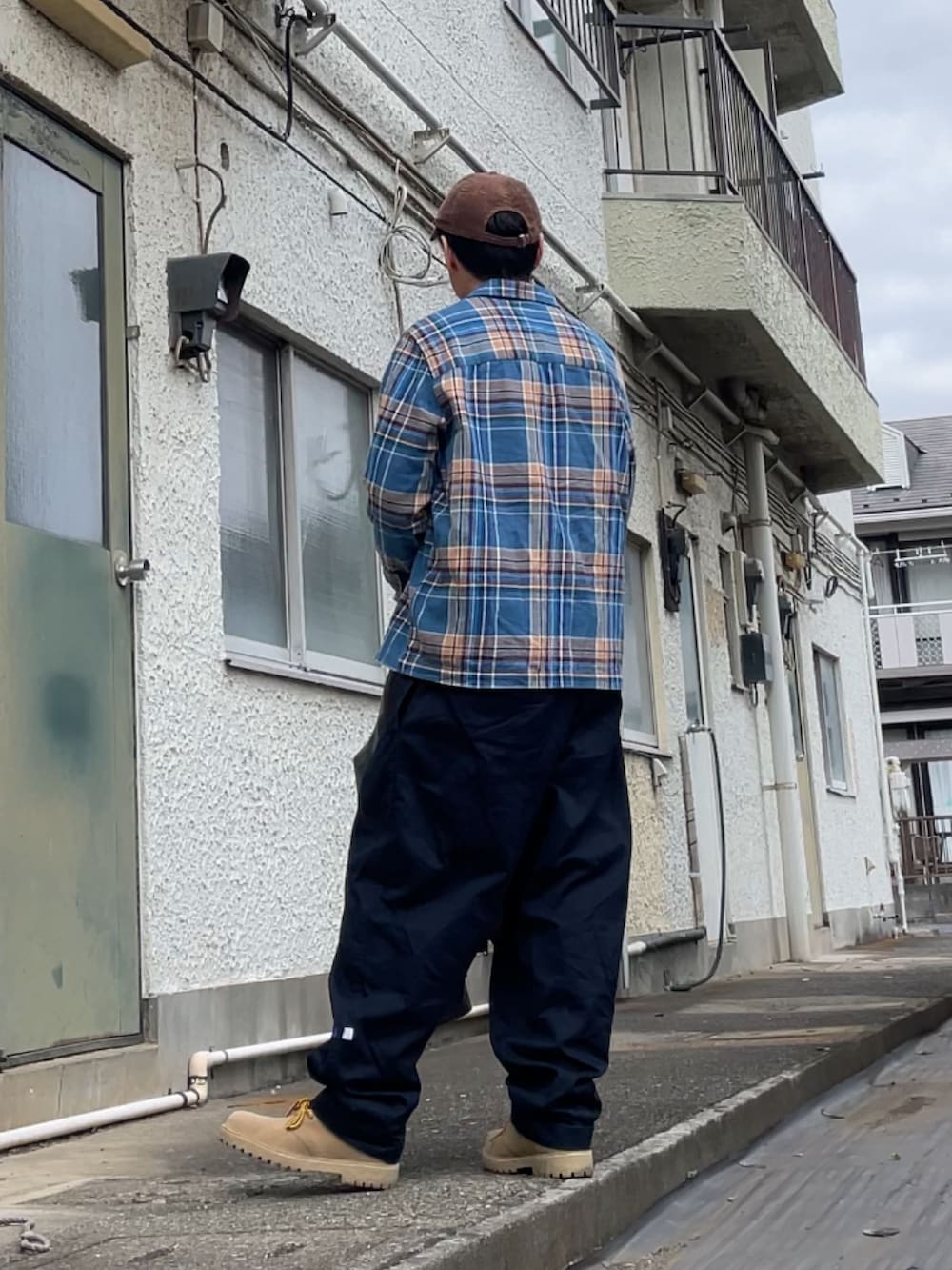 ブルー系のシャツ/ブラウス、ブルー系のチノパンツ、ブラウン系のブーツを着用したメンズの冬コーディネートの2枚目の写真