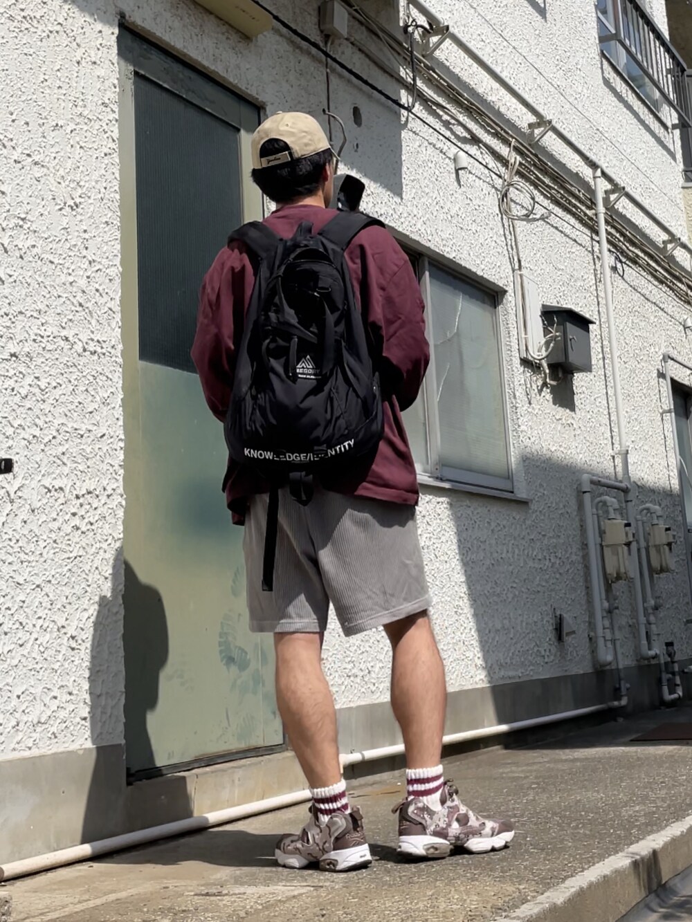 ブラウン系のスニーカー、グレー系のその他パンツ、レッド系のスウェットを着用したメンズの春コーディネートの4枚目の写真