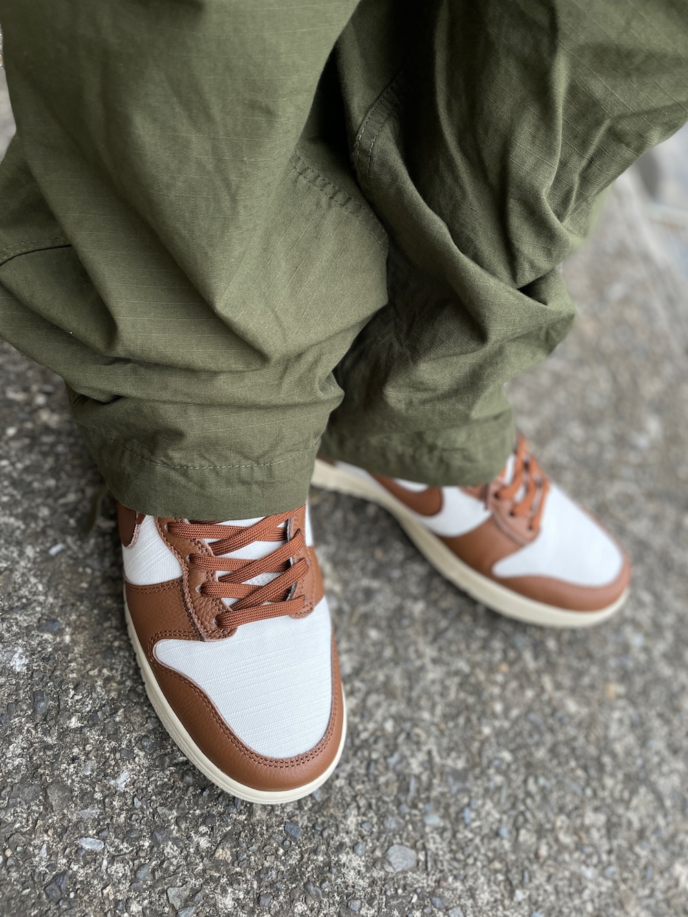 ブラウン系のスニーカー、グリーン系のカーゴパンツ、ホワイト系のTシャツ/カットソーを着用したメンズの夏コーディネートの3枚目の写真