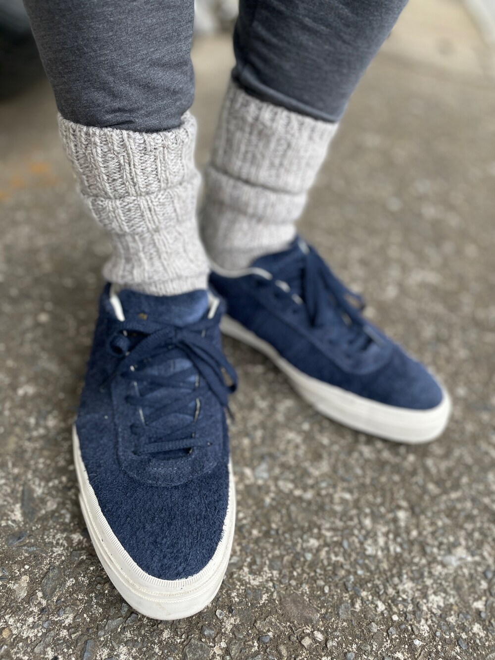 ブルー系のスニーカー、ブルー系のデニムパンツ、グリーン系のポロシャツを着用したメンズの春コーディネートの3枚目の写真