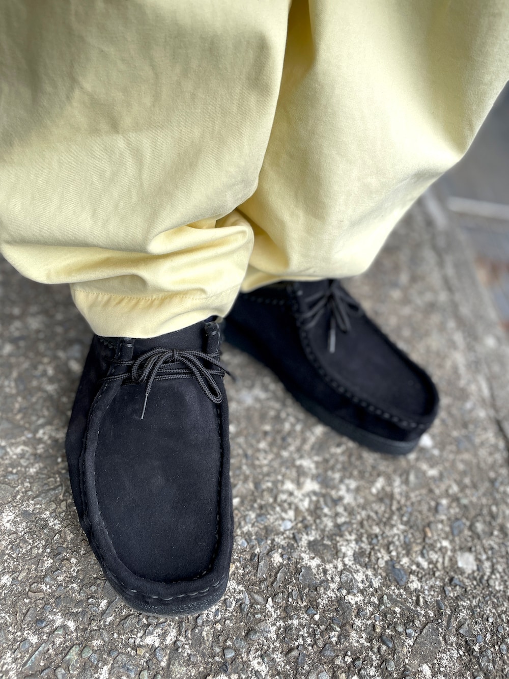 ブラック系のモカシン/デッキシューズ、イエロー系のその他パンツ、ブラック系のTシャツ/カットソーを着用したメンズの春コーディネートの3枚目の写真