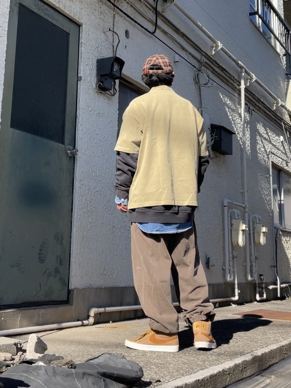 ブラウン系のスニーカー、ブラウン系のその他パンツ、グリーン系のTシャツ/カットソーを着用したメンズの冬コーディネートの3枚目の写真