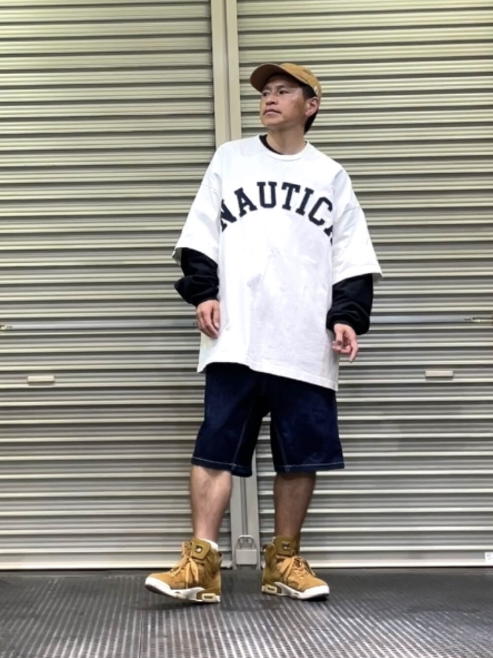 ブラウン系のスニーカー、ブルー系のデニムパンツ、ホワイト系のTシャツ/カットソーを着用したメンズの春コーディネートの3枚目の写真