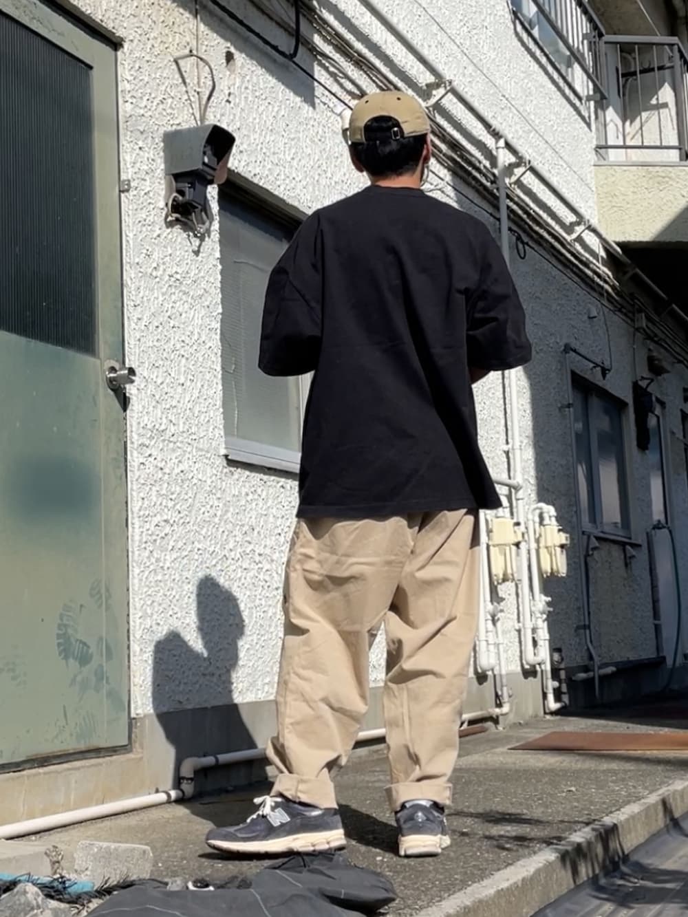 ブルー系のスニーカー、ベージュ系のその他パンツ、ブラック系のTシャツ/カットソーを着用したメンズの秋コーディネートの2枚目の写真