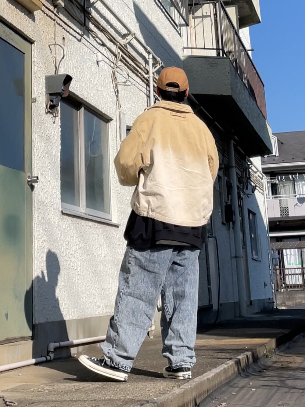 ブラック系のスニーカー、ブルー系のデニムパンツ、ブラック系のスウェットを着用したメンズの冬コーディネートの2枚目の写真