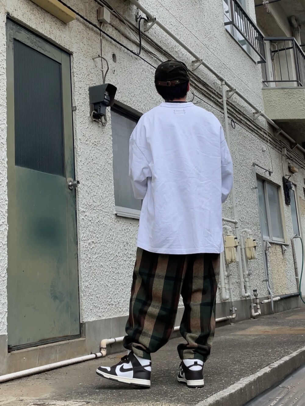 ブラウン系のスニーカー、ブラウン系のパンツ、ホワイト系のTシャツ/カットソーを着用したメンズの春コーディネートの2枚目の写真