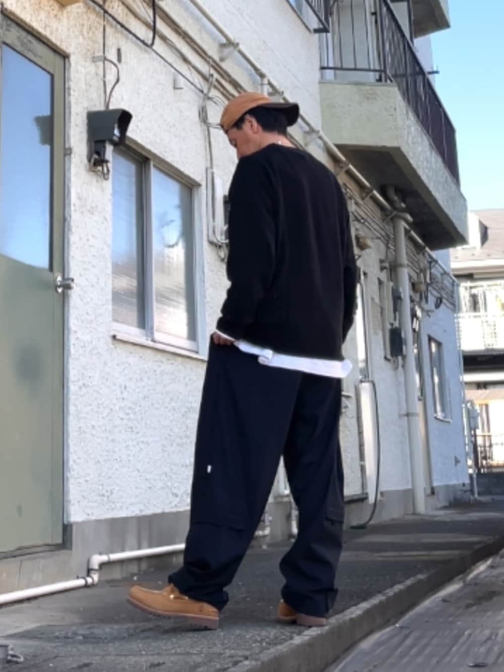 ブラック系のニット/セーター、ブルー系のカーゴパンツ、イエロー系のモカシン/デッキシューズを着用したメンズの冬コーディネートの2枚目の写真