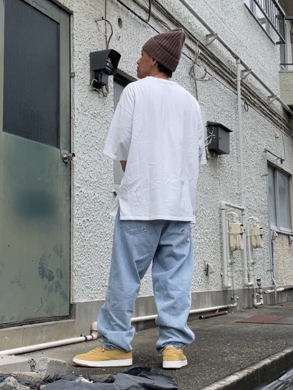 ベージュ系のスニーカー、ブルー系のデニムパンツ、ホワイト系のTシャツ/カットソーを着用したメンズの秋コーディネートの2枚目の写真