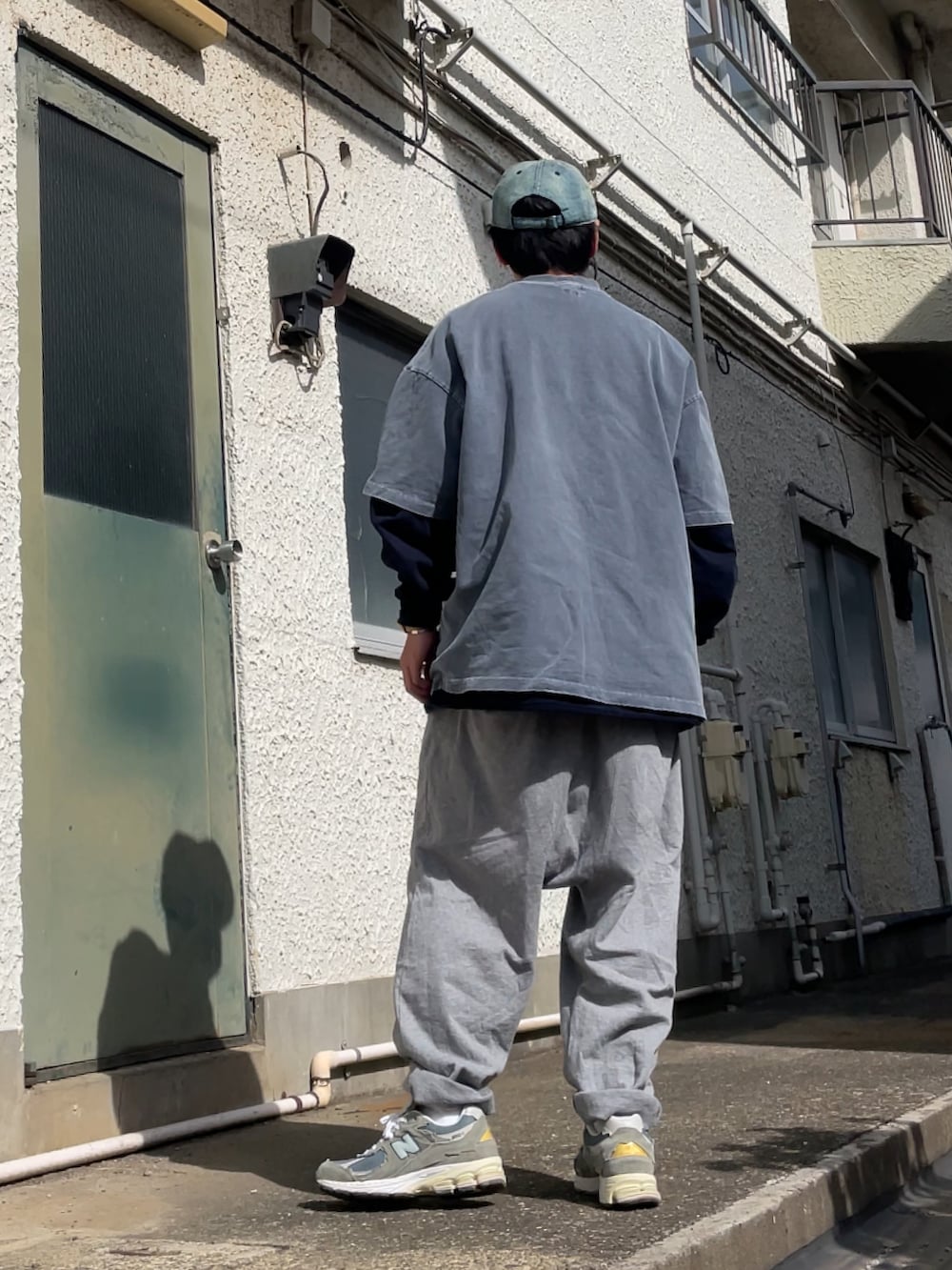 グレー系のスニーカー、グレー系のその他パンツ、ブルー系のTシャツ/カットソーを着用したメンズの春コーディネートの2枚目の写真