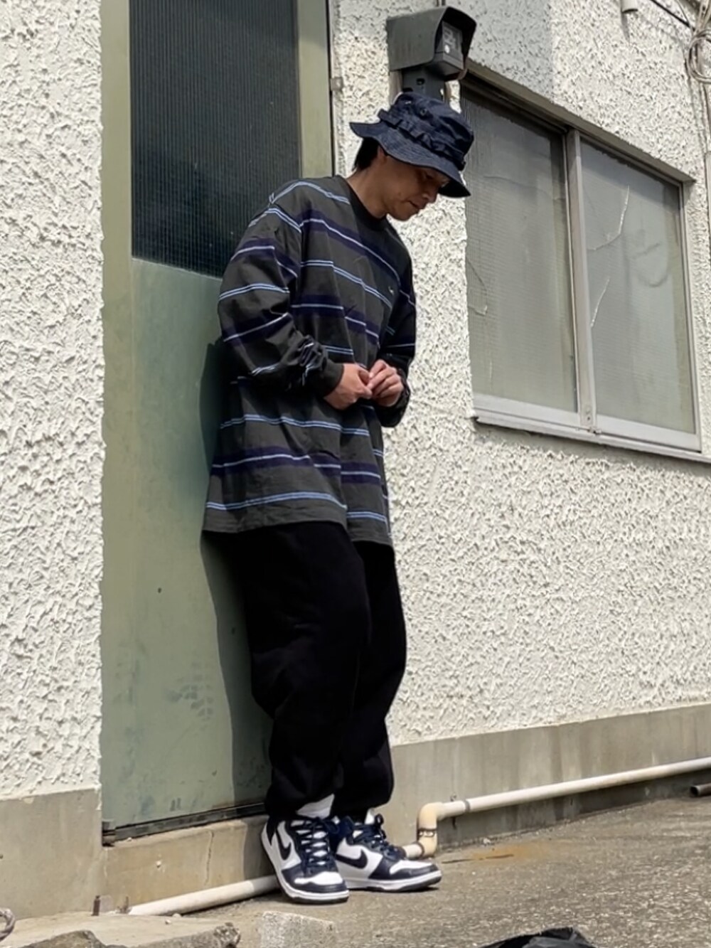 ブルー系のスニーカー、ブラック系のその他パンツ、ブルー系のTシャツ/カットソーを着用したメンズの春コーディネートの3枚目の写真