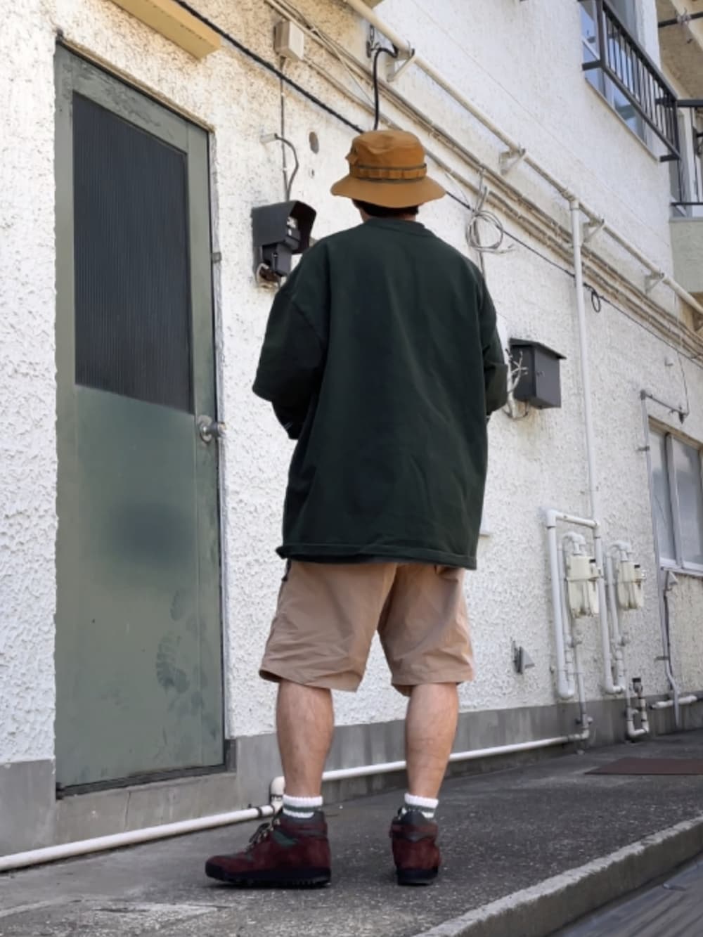 ブラウン系のスニーカー、ベージュ系のその他パンツ、グリーン系のTシャツ/カットソーを着用したメンズの春コーディネートの2枚目の写真