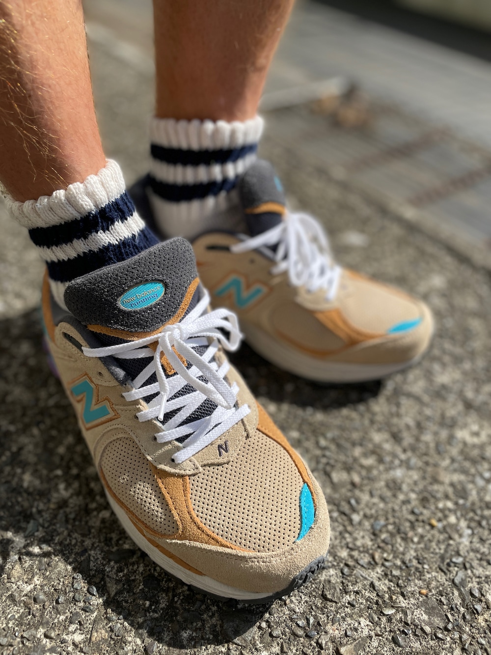 ベージュ系のスニーカー、ブラウン系のその他パンツ、ブルー系のTシャツ/カットソーを着用したメンズの夏コーディネートの3枚目の写真