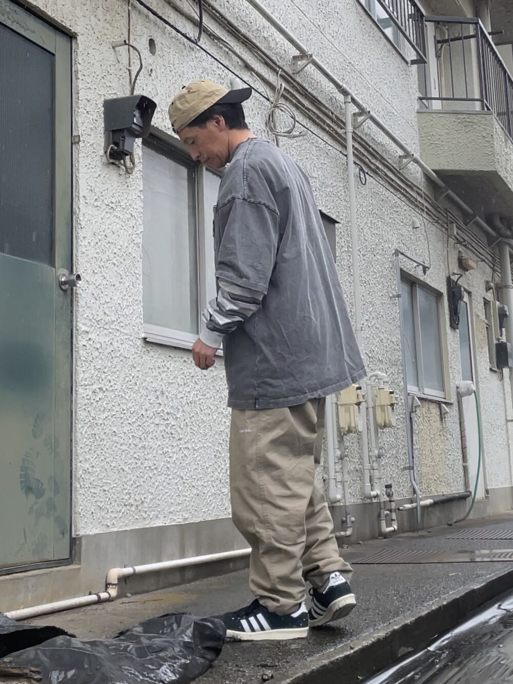 ブラック系のスニーカー、ベージュ系のチノパンツ、グレー系のTシャツ/カットソーを着用したメンズの春コーディネートの2枚目の写真