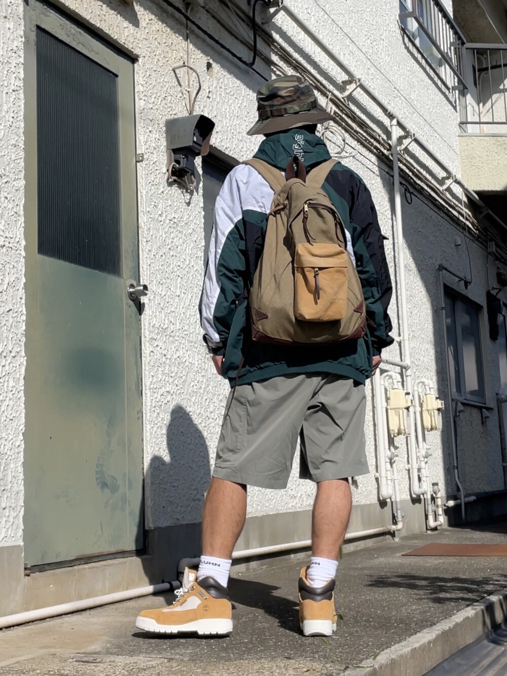 ブラウン系のブーツ、ブラウン系のその他パンツ、グリーン系のマウンテンパーカーを着用したメンズの秋コーディネートの4枚目の写真