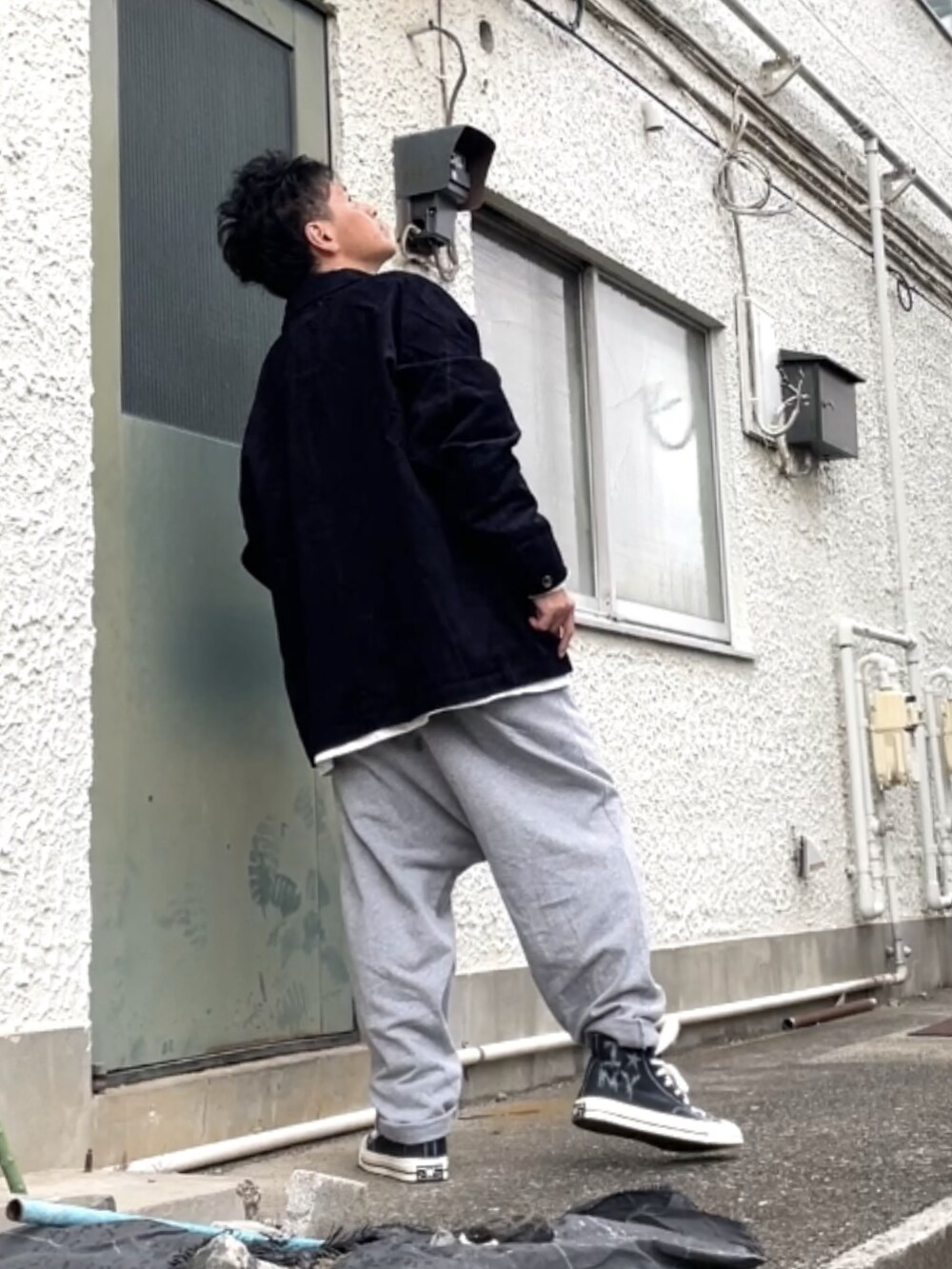 ブラック系のスニーカー、グレー系のその他パンツ、ブルー系のジャケット/アウターを着用したメンズの秋コーディネートの2枚目の写真