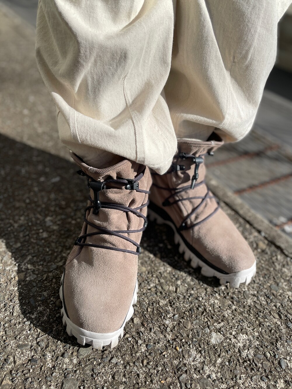 ブラウン系のスニーカー、ホワイト系のデニムパンツ、ベージュ系のスウェットを着用したメンズの春コーディネートの3枚目の写真