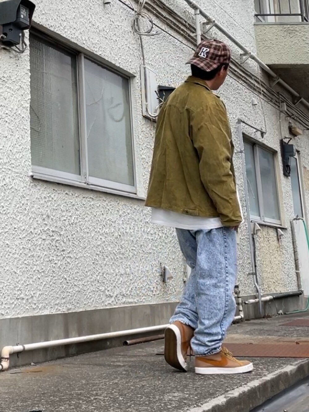 ブラウン系のスニーカー、ブルー系のデニムパンツ、ホワイト系のTシャツ/カットソーを着用したメンズの春コーディネートの3枚目の写真